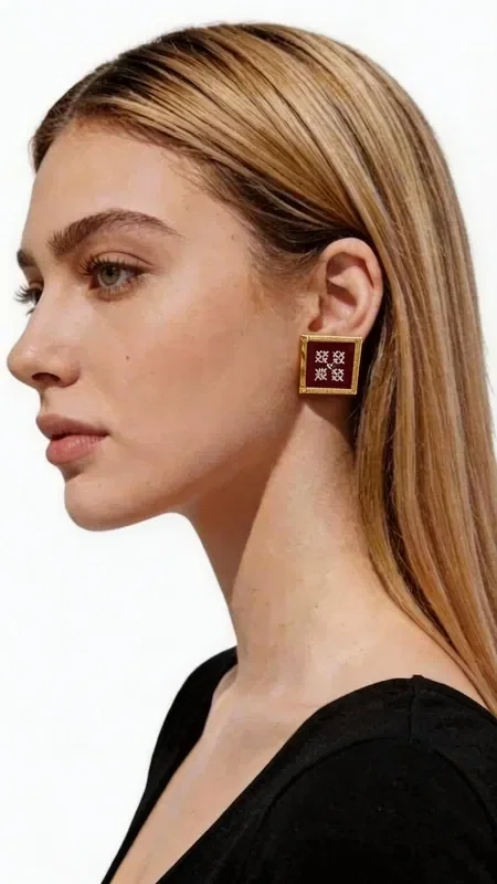, These statement embroidered earrings with geometric patterns in gold thread on a stunning burgundy background add a unique touch of elegance to every look. Designed by Greek Jewelry Designer Aikaterini Chalkiadaki, these striking handmade earrings combine the traditional art of embroidery with contemporary design.

Each earring is crafted with special attention to detail, using gold thread that forms geometric motifs on a deep burgundy background. The square shape with a gold outline offers a modern interpretation of classic embroidery, ideal for women who love statement jewelry.

These unique earrings are perfect for special occasions such as weddings, evening outings, or professional events. They pair beautifully with monochrome outfits, adding color and elegance.

Material: Brass, Fabric
Care: Store in a dry place and avoid contact with water and chemical products to preserve the colors.