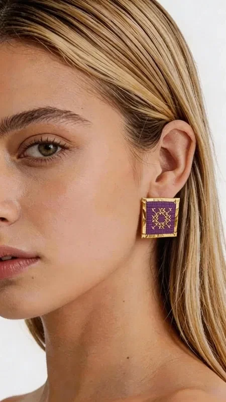 , The statement earrings embroidered with gold thread in a striking burgundy color are the ideal choice for women seeking unique style and elegance. These handmade earrings, designed by Greek Jewelry Designer Aikaterini Chalkiadaki, stand out for their impressive geometric patterns and high-quality craftsmanship. The square shape with gold outlines and richly embroidered surface creates a unique combination of traditional technique and modern design. The deep burgundy color offers luxury and elegance, while the gold details add shine and sophistication.

These eye-catching earrings are perfect for special occasions such as weddings, events, or evening outings, but they can also elevate your everyday look. Greek craftsmanship and attention to detail make them unique pieces that will stand out in your collection.

Material: Brass, Fabric

Handle with care, avoiding contact with water and perfumes to preserve their shine.