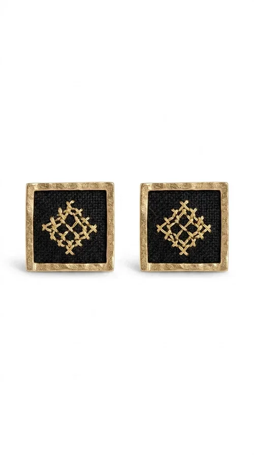 , Embroidered statement earrings with geometric patterns are the ideal choice for anyone who wants to add a touch of individuality and character to their look. The square black fabric with gold embroidered details in a diamond-shaped geometric motif creates a striking result that combines the traditional art of embroidery with modern design. Designed by Greek Jewelry Designer Aikaterini Chalkiadaki, these handmade earrings are a piece with a strong aesthetic identity that evokes folk tradition.

Made of brass and fabric, these earrings combine two materials with different textures and character. The gold brass frame surrounds the black fabric square, while the embroidered geometric pattern gives depth and richness to the composition. The result is a stud earring that is comfortable to wear and automatically becomes the focal point of any look.

They suit both casual and formal looks equally well — from a simple linen jacket to an evening outfit. Also ideal as a gift for women who love unique, handmade jewelry with a Greek aesthetic.