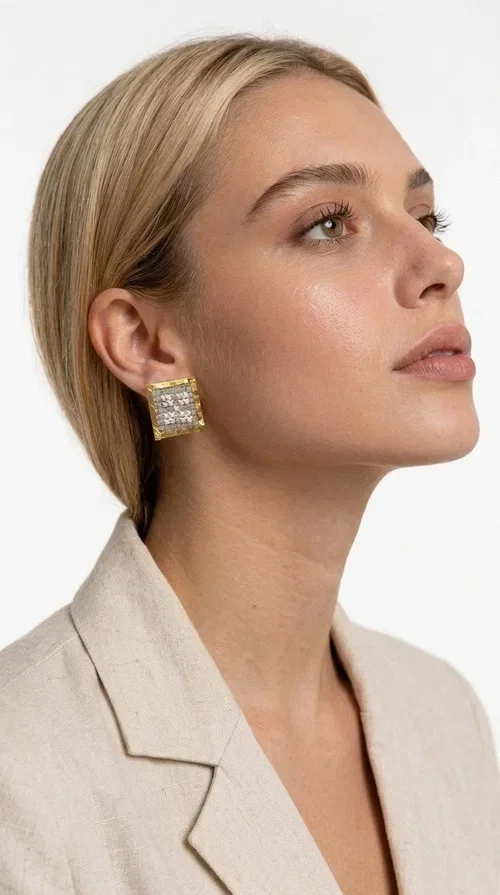 , The embroidered statement earrings with geometric patterns in a cream shade are the ideal choice for those seeking an accessory with character and handmade finesse. With a square shape and detailed embroidery covering their entire surface, they form a unique piece of jewelry that combines traditional techniques with a contemporary aesthetic.

Designed by Greek Jewelry Designer Aikaterini Chalkiadaki, these handmade earrings are crafted from brass and fabric, creating a striking combination of materials. The geometric embroidery in cream tones gives off a warm, boho-chic vibe that suits both casual and formal looks alike — from an everyday stroll to a wedding or christening.

These square-shaped stud earrings sit comfortably on the ear and allow for hair-up styling, as shown in the image, fully highlighting their elegant geometry. Ideal as a gift for women who appreciate unique, handmade jewelry of Greek design.