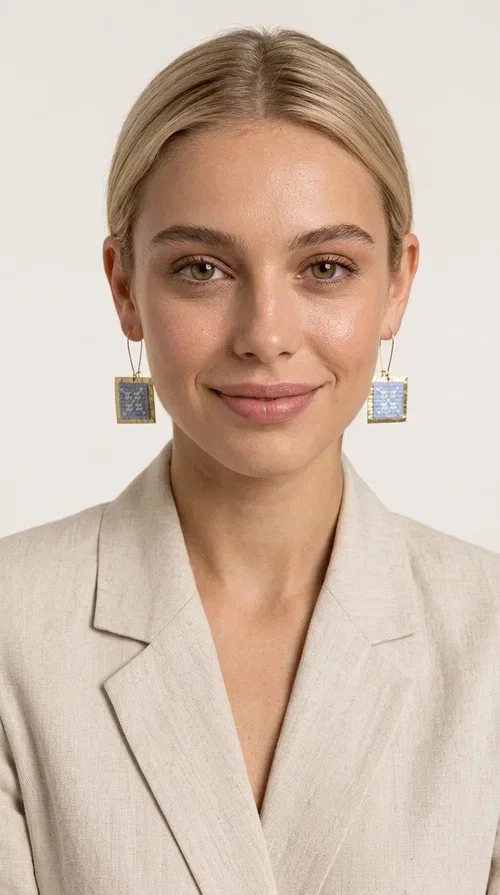 , The embroidered statement earrings with geometric designs in light blue are a bold choice for every woman who wants to express herself through her jewelry. Designed by Greek Jewelry Designer Aikaterini Chalkiadaki, these striking handmade earrings combine the traditional art of embroidery with a modern, geometric aesthetic.

Their square shape, featuring a gold-tone brass hoop, highlights the light blue embroidered fabric adorned with delicate geometric details — a result that evokes Greek folk art and a folklore aesthetic. Each pair is unique thanks to its handmade craftsmanship, making it a true treasure for your collection.

Ideal for weddings, christenings, formal occasions, and even for elevating an everyday look, these earrings pair beautifully with white, ecru, or blue outfits. Lightweight to wear and comfortable to have on.
