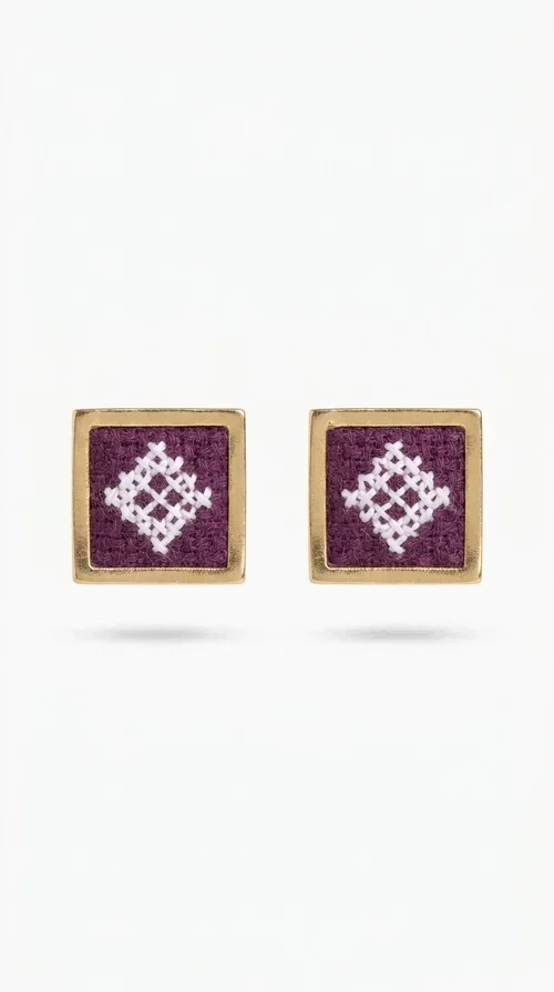 , The embroidered statement earrings with geometric patterns in magenta are the ideal choice for every woman who wants to express herself through unique, handmade jewelry. Designed by Greek Jewelry Designer Aikaterini Chalkiadaki, these striking stud earrings combine the traditional art of embroidery with a modern aesthetic result, creating a piece of jewelry that truly stands out.

Each pair consists of square earrings with gold brass framing embroidered fabric in a vivid magenta color, decorated with delicate geometric motifs in white — a combination that evokes folklore aesthetics and Greek tradition. The result is a jewelry piece with character, instantly elevating any look, from casual outfits to formal events.

Ideal for weddings, christenings, summer events, or everyday looks you want to make a statement with, these handmade earrings pair perfectly with white, ecru, or monochrome outfits.