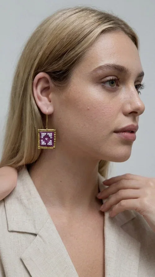, The embroidered statement earrings in a vibrant magenta shade are the definition of jewelry that never goes unnoticed — a bold choice for those who love to express themselves through their style.

Designed by Greek Jewelry Designer Aikaterini Chalkiadaki, these striking handmade earrings combine geometric embroidered patterns in magenta and white, set within a square brass frame in a gold hue. The embroidery technique adds depth and texture to the piece, bringing forward a folk and folklore aesthetic that nods to Greek tradition in a modern way.

The dangling design with a delicate hook lets the earrings sway elegantly, elevating every look — from casual everyday outfits to evening outings, weddings, or festive occasions. The bold magenta hue pairs beautifully with neutral colors (white, beige, black) as well as with daring color combinations.