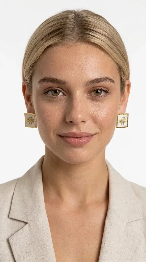 , Embroidered statement earrings with geometric designs in white are the perfect choice for those seeking an accessory that combines folk tradition with contemporary style. Designed by Greek Jewelry Designer Aikaterini Chalkiadaki, these handmade stud earrings are a unique piece that stands out with its embroidered technique and geometric folk-inspired patterns.

Made of brass and fabric, these earrings feature a square shape with white embroidery and gold geometric details reminiscent of folklore tradition. The white color makes them versatile and easy to pair with any outfit — from casual everyday looks to formal occasions, weddings, and christenings. Their lightweight design ensures comfort throughout the day.

Ideal for women who love striking jewelry with character, these boho earrings flatter every face shape thanks to their structured form. Perfect as a gift for any occasion.