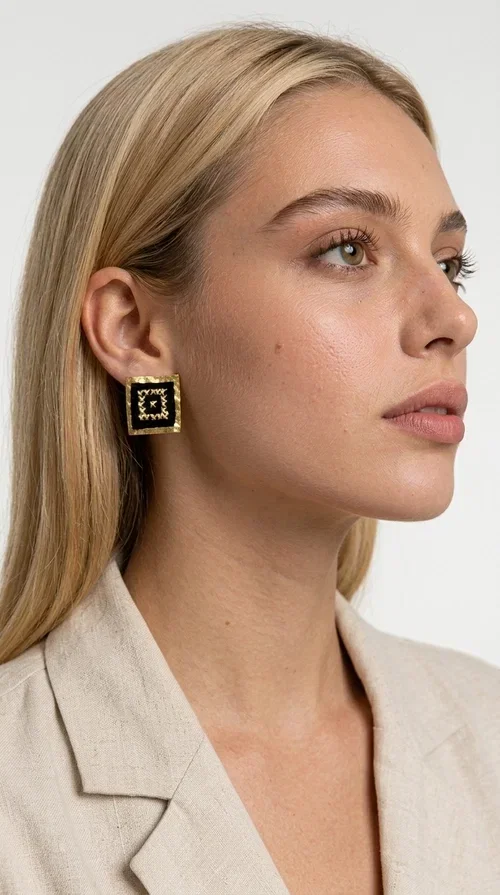 , Embroidered statement earrings with geometric designs in black are the ideal choice for every woman who wants to express herself through her accessories. With a square shape and a striking combination of black fabric and gold-toned brass, these handmade stud earrings are a unique piece of jewelry that blends the traditional art of embroidery with a modern aesthetic. Designed by Greek Jewelry Designer Aikaterini Chalkiadaki, they reflect Greek craftsmanship in its most refined expression.

The geometric motif adorning each earring evokes a folk and ethnic aesthetic, while the square brass structure gives character and shape to the overall design. The black fabric combined with the gold detailing creates a striking visual contrast that immediately catches the eye. Perfect for formal occasions, weddings, evening outings, and boho everyday looks alike.