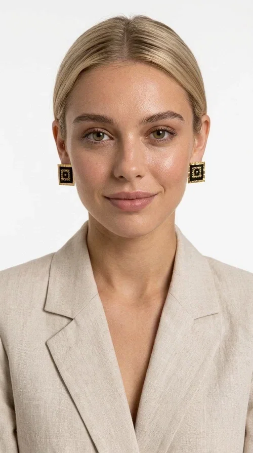 , Embroidered statement earrings with geometric designs in black are the ideal choice for every woman who wants to express herself through her accessories. With a square shape and a striking combination of black fabric and gold-toned brass, these handmade stud earrings are a unique piece of jewelry that blends the traditional art of embroidery with a modern aesthetic. Designed by Greek Jewelry Designer Aikaterini Chalkiadaki, they reflect Greek craftsmanship in its most refined expression.

The geometric motif adorning each earring evokes a folk and ethnic aesthetic, while the square brass structure gives character and shape to the overall design. The black fabric combined with the gold detailing creates a striking visual contrast that immediately catches the eye. Perfect for formal occasions, weddings, evening outings, and boho everyday looks alike.