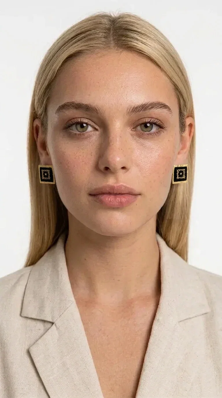 , Embroidered statement earrings with geometric designs in black are the ideal choice for every woman who wants to express herself through her accessories. With a square shape and a striking combination of black fabric and gold-toned brass, these handmade stud earrings are a unique piece of jewelry that blends the traditional art of embroidery with a modern aesthetic. Designed by Greek Jewelry Designer Aikaterini Chalkiadaki, they reflect Greek craftsmanship in its most refined expression.

The geometric motif adorning each earring evokes a folk and ethnic aesthetic, while the square brass structure gives character and shape to the overall design. The black fabric combined with the gold detailing creates a striking visual contrast that immediately catches the eye. Perfect for formal occasions, weddings, evening outings, and boho everyday looks alike.