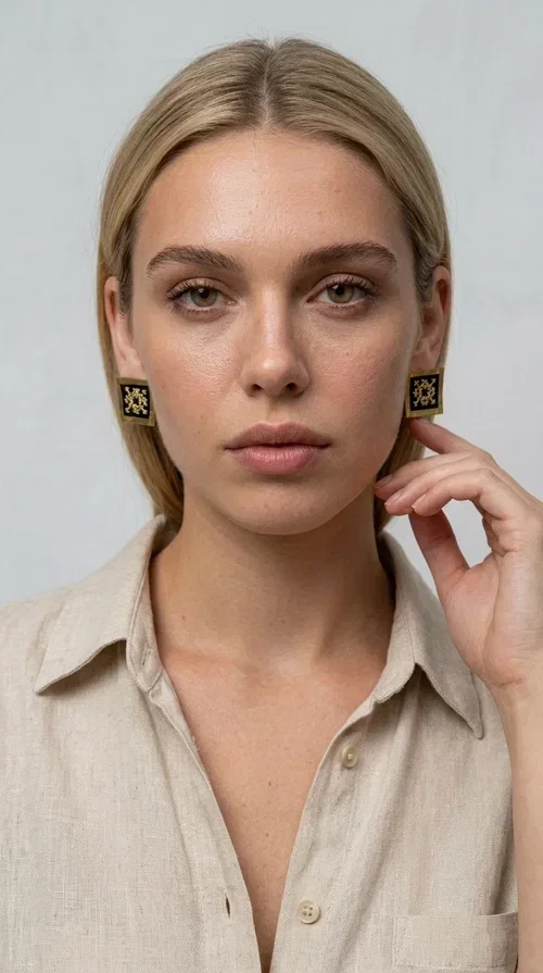 , The embroidered statement earrings with geometric patterns in black are the ideal choice for those seeking an accessory that combines folk tradition with modern aesthetics. Designed by Greek Jewelry Designer Aikaterini Chalkiadaki, these handmade earrings are a small wearable work of art.

Each pair is made of brass and fabric, with embroidered motifs inspired by Greek folk art. Their square, flat shape and golden geometric patterns set against a black background create a striking visual contrast, making them stand out in any look. These stud earrings suit both casual and formal outfits equally well.

Wear them with a simple everyday look to instantly elevate it, or choose them for a wedding, an evening out, or a professional event. They also make a wonderful gift idea for women who appreciate handmade jewelry with character.