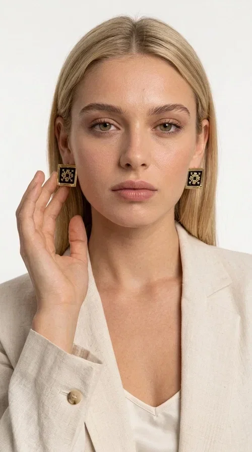 , The embroidered statement earrings with geometric patterns in black are the ideal choice for those seeking an accessory that combines folk tradition with modern aesthetics. Designed by Greek Jewelry Designer Aikaterini Chalkiadaki, these handmade earrings are a small wearable work of art.

Each pair is made of brass and fabric, with embroidered motifs inspired by Greek folk art. Their square, flat shape and golden geometric patterns set against a black background create a striking visual contrast, making them stand out in any look. These stud earrings suit both casual and formal outfits equally well.

Wear them with a simple everyday look to instantly elevate it, or choose them for a wedding, an evening out, or a professional event. They also make a wonderful gift idea for women who appreciate handmade jewelry with character.
