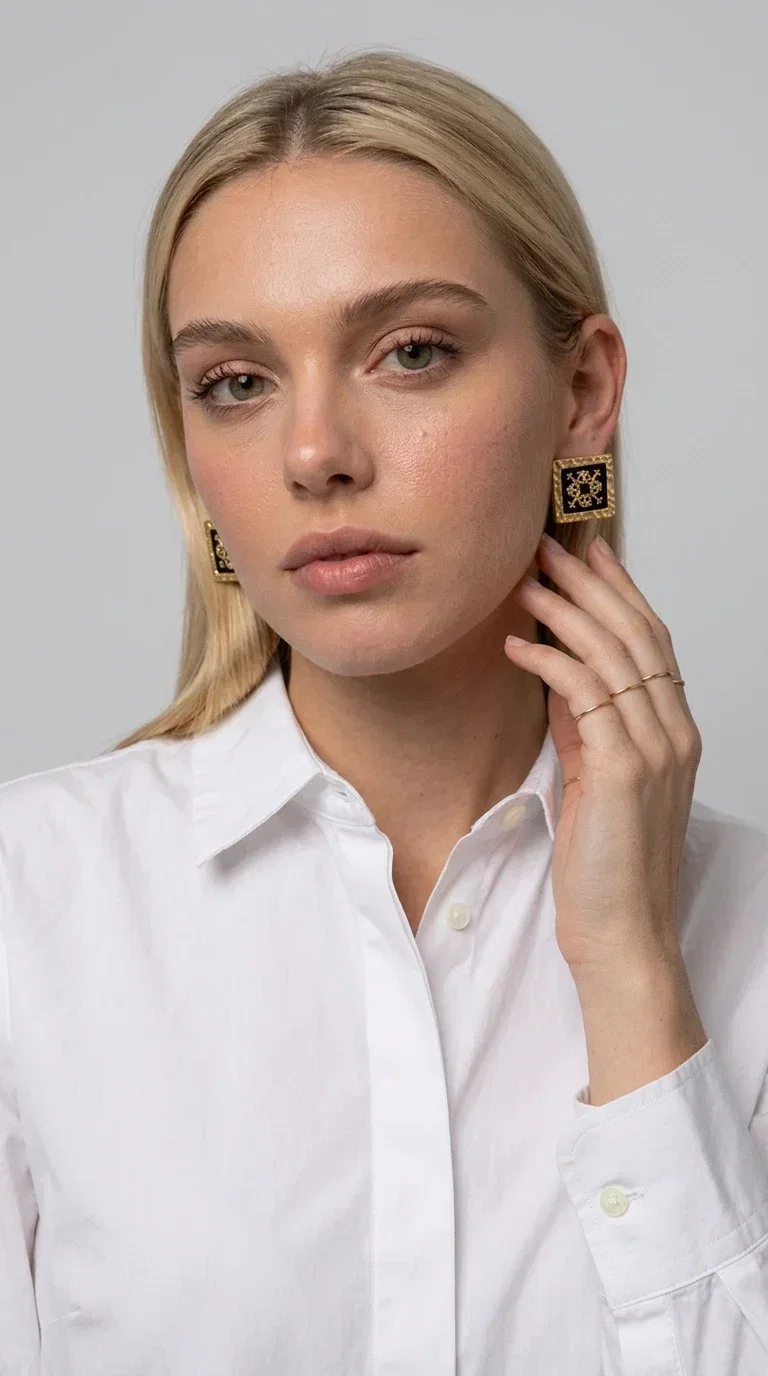, The embroidered statement earrings with geometric patterns in black are the ideal choice for those seeking an accessory that combines folk tradition with modern aesthetics. Designed by Greek Jewelry Designer Aikaterini Chalkiadaki, these handmade earrings are a small wearable work of art.

Each pair is made of brass and fabric, with embroidered motifs inspired by Greek folk art. Their square, flat shape and golden geometric patterns set against a black background create a striking visual contrast, making them stand out in any look. These stud earrings suit both casual and formal outfits equally well.

Wear them with a simple everyday look to instantly elevate it, or choose them for a wedding, an evening out, or a professional event. They also make a wonderful gift idea for women who appreciate handmade jewelry with character.