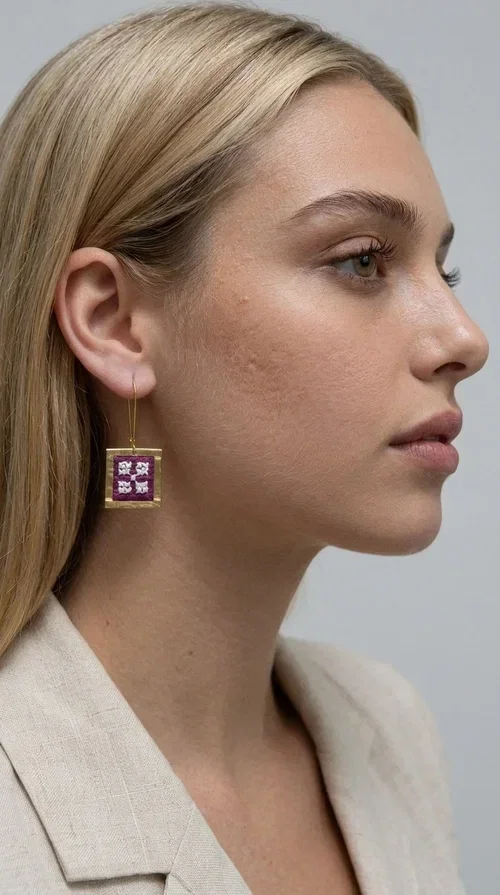, The embroidered statement earrings with geometric patterns in magenta are the ideal choice for every woman who wants to express herself through her style. Designed by Greek Jewelry Designer Aikaterini Chalkiadaki, these handmade earrings combine the traditional art of embroidery with a modern, geometric aesthetic that instantly catches the eye.

The square brass frame in a gold finish surrounds an embroidered fabric in a bold magenta color with white geometric details, creating a bold, folklore-inspired result. The dangling design with hook makes the earrings lightweight to wear and comfortable for all-day use, while their size is perfect for making a statement without being over the top.

Ideal for weddings, christenings, festive events, but also for a casual chic look with a white shirt or dress. The magenta color pairs beautifully with neutral colors such as beige, white, and black.