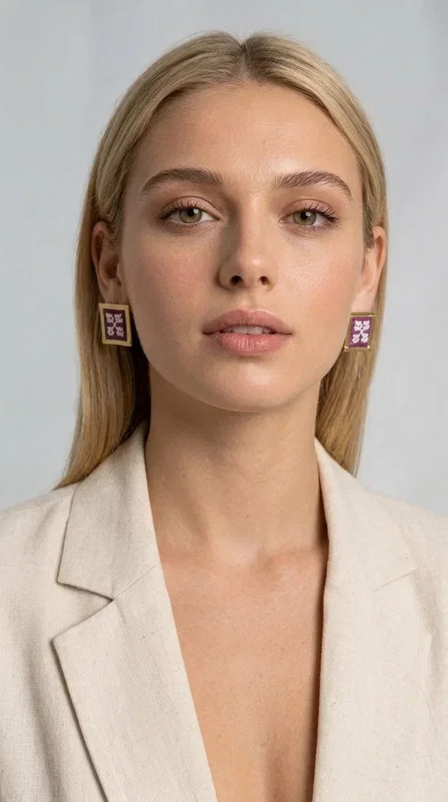 , The embroidered statement earrings with geometric designs in magenta are a bold choice for every woman who wants to express herself through her style. Designed by Greek Jewelry Designer Aikaterini Chalkiadaki, these handmade stud earrings combine folklore aesthetics with contemporary geometric composition, creating a result that immediately catches the eye.

Made from brass and fabric, they feature a square frame with a golden finish and an embroidered inner motif in a striking magenta shade, with delicate floral-geometric details reminiscent of traditional Greek folk art. The result is a jewelry piece with character and depth, ideal for elevating even the simplest outfit.

Perfect for weddings, christenings, nights out, or everyday looks that call for something extra, these earrings pair beautifully with white, black, or neutral clothing that lets the jewelry take center stage.