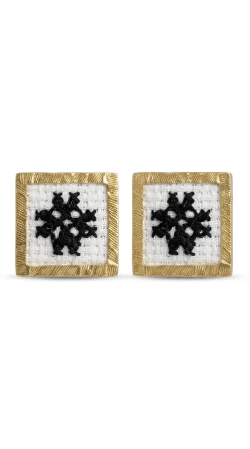 , Embroidered statement earrings with geometric patterns are the ideal choice for those seeking an accessory that combines folk tradition with contemporary style. Designed by Greek Jewelry Designer Aikaterini Chalkiadaki, they are handmade jewelry pieces that highlight the charm of folklore aesthetics in a striking and timeless way.

Each pair features a square shape with a gold brass frame and finely worked embroidery in white and black, forming a geometric snowflake-inspired motif drawn from traditional Greek art. The result is a stud earring that immediately catches the eye, without being overly heavy or bulky — ideal for both everyday and formal wear.

They pair perfectly with casual looks and linen outfits, as well as with formal appearances at weddings, christenings, or summer events. The simplicity of their design makes them versatile, while the embroidery gives them a unique, artisan character.