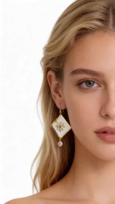 , Discover the magic of embroidered statement earrings with geometric patterns, a work of art designed by Greek Jewelry Designer Aikaterini Chalkiadaki. These striking handmade earrings combine white elegance with golden details, creating a unique piece of jewelry that stands out.

Each earring is adorned with geometric embroidery in gold thread on a white base, finished with an elegant pearl hanging at the bottom. The diamond shape with the gold star-like decoration gives it a modern aesthetic, making it ideal for special moments and formal occasions.

These striking dangle earrings are the perfect choice for women who love original handmade jewelry. Pair them with classic or modern outfits for a look that will steal the show.

Care for them gently with a dry cloth and store them in a dry place to preserve their shine.