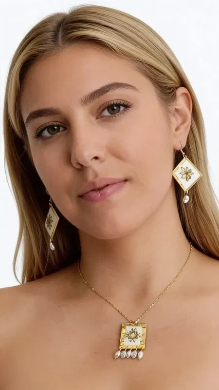 , Discover the magic of embroidered statement earrings with geometric patterns, a work of art designed by Greek Jewelry Designer Aikaterini Chalkiadaki. These striking handmade earrings combine white elegance with golden details, creating a unique piece of jewelry that stands out.

Each earring is adorned with geometric embroidery in gold thread on a white base, finished with an elegant pearl hanging at the bottom. The diamond shape with the gold star-like decoration gives it a modern aesthetic, making it ideal for special moments and formal occasions.

These striking dangle earrings are the perfect choice for women who love original handmade jewelry. Pair them with classic or modern outfits for a look that will steal the show.

Care for them gently with a dry cloth and store them in a dry place to preserve their shine.
