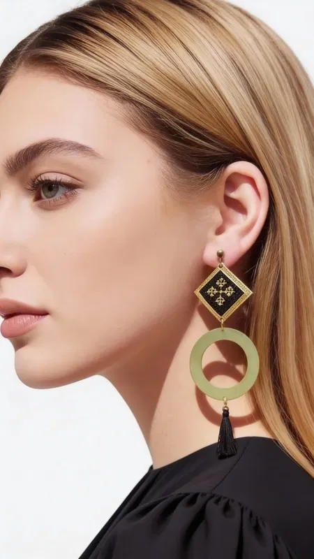 , Make a statement with these stunning geometric drop earrings that beautifully blend traditional Greek folk art with contemporary design. Each earring features an intricately embroidered black textile panel adorned with geometric motifs rendered in gleaming gold thread, creating a sophisticated contrast that catches the light with every movement.
The masterful craftsmanship showcases hand-stitched chrysoklosti (gold thread) detailing, with each geometric pattern meticulously embroidered onto rich black fabric. This textile artistry is elegantly framed in a solid brass diamond-shaped setting, which flows seamlessly into a circular brass element. The design culminates in a luxurious black tassel that adds movement and texture, creating an impressive statement piece that measures approximately 3-4 inches in length.
Inspired by the rich heritage of Greek embroidery traditions, these earrings celebrate the timeless art of kentima while offering a thoroughly modern interpretation for today's sophisticated woman.
These versatile statement pieces transition effortlessly from day to evening wear, adding artistic flair to both casual and formal ensembles. Perfect for the woman who appreciates handcrafted artistry and wants to make a memorable impression.
Care Instructions:
Store flat to prevent tangling. Clean brass elements with a soft cloth. Keep embroidered textiles dry and handle gently to preserve intricate stitching.