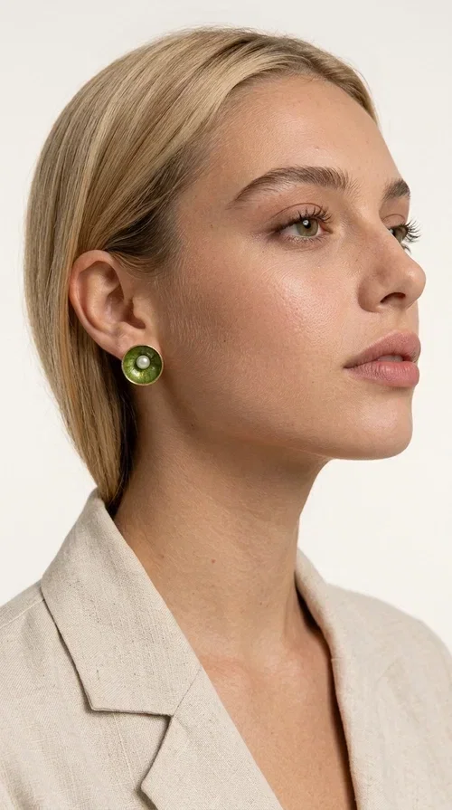 , Khaki pearl stud earrings are the ideal choice for every woman seeking elegance with character. Designed by Greek Jewelry Designer Aikaterini Chalkiadaki, these handmade earrings combine the beauty of pearls with the earthy aesthetic of khaki enamel, creating a jewelry piece with strong personality.

Their round shape, crafted in deep khaki green enamel on brass, gains a special charm thanks to the central pearl that stands out with its white shine. The delicate textured pattern of the enamel adds depth and movement, making each pair unique. They are comfortable to wear thanks to the secure post fastening, while their size is ideal — striking enough to become the focal point of your look, without being overwhelming.

They pair equally well with casual everyday looks and more formal outfits, and they also make an excellent choice as a bridal accessory or a gift for special occasions.