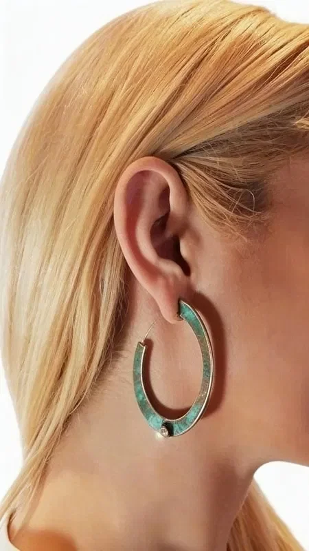 , Striking hoop earrings with pearls that combine the natural beauty of copper with the elegance of pearls. These large stud earrings, designed by Greek Jewelry Designer Aikaterini Chalkiadaki, feature a unique green patina that adds vintage character and authenticity.

Each earring features a white pearl strategically placed at the bottom of the hoop, creating a perfect contrast with the oxidized copper surface. The handmade construction and natural patina make each pair unique, while the open hoop design offers comfort and style.

Ideal for women who love statement jewelry with boho elements, these earrings complete both casual and formal looks. The classic hoop shape combined with the pearl makes them suitable for weddings, special occasions, and everyday wear.