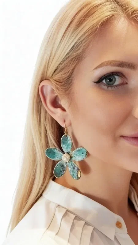 , Large statement dangle earrings with pearls that combine boho style with a modern aesthetic. These unique handmade women's flower earrings, designed by Greek Jewelry Designer Aikaterini Chalkiadaki, stand out for their modern patina finish that creates striking green tones with golden accents.

Each earring is shaped like a daisy with six oval petals made of oxidized brass, while the center holds a natural pearl that adds elegance and light. The oxidized brass technique gives unique color variations that make each piece one of a kind. Their size makes these impressive earrings the ideal choice for weddings or special occasions.

Perfect for pairing with boho outfits or adding a pop of color to monochrome looks.