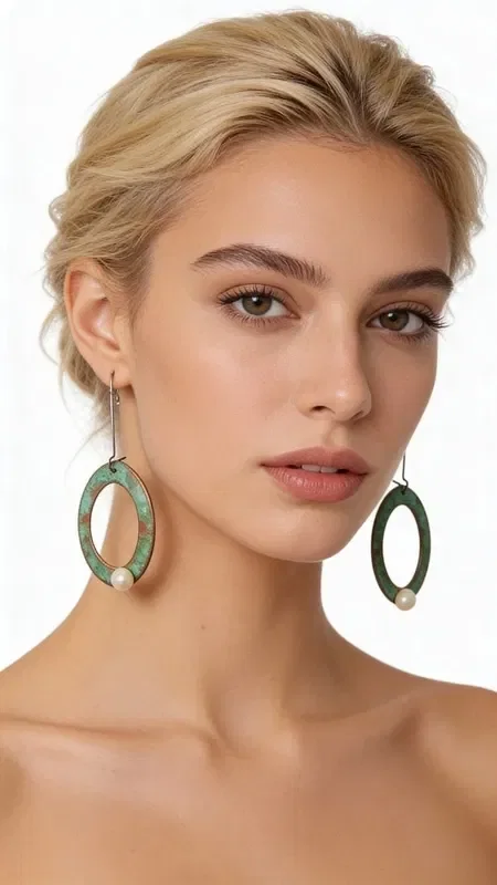 , Discover the magic of large pearl hoop drop earrings that combine vintage aesthetics with modern elegance. Each piece is handmade and designed by Greek Jewelry Designer Aikaterini Chalkiadaki, offering a unique style statement.

These striking earrings feature oval bronze hoops with a beautiful green patina that creates a vintage character. Each hoop holds a white pearl that adds elegance and brightness to the design. The contrast between the warm bronze and the white pearls creates an exceptional color combination.

These long drop earrings are ideal for weddings, evening outings, or any moment you want to stand out. Their lightweight construction ensures comfortable wear all day long. Store in a dry place and clean gently with a soft cloth.
