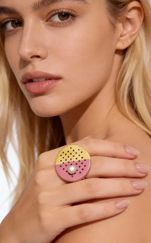 , An impressive statement ring that combines classic elegance with modern design. This unique handmade piece, designed by Greek Jewelry Designer Aikaterini Chalkiadaki, is the perfect choice for the woman who wants to stand out.

The geometric circular brass base features a striking combination of colors - gold and fuchsia pink - creating a contemporary yin-yang aesthetic. The perforated surface with geometric holes gives it an industrial character, while the white pearl at the center adds a touch of elegance and femininity.

The large size of the ring makes it ideal for special occasions and evening outings. It pairs beautifully with monochrome outfits, adding color and style to any look.