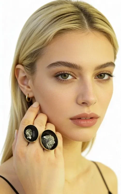 , Discover the perfect balance between strength and elegance with this large statement women's ring featuring double pyrite, designed by Aikaterini Chalkiadaki. This unique handmade ring combines two natural pyrite crystals in a striking composition that catches every eye.

The black patina creates an impressive contrast with the golden pyrite crystals, while the brass adds warmth and durability to the piece. The open design of the ring allows for comfortable fit across various finger sizes, while the two oval pyrite stones in different sizes create a dynamic composition.

Pyrite is considered a stone of protection and strength, ideal for women who want to express their personality with style. This statement ring pairs perfectly with both casual and formal outfits, adding a unique character to any look.