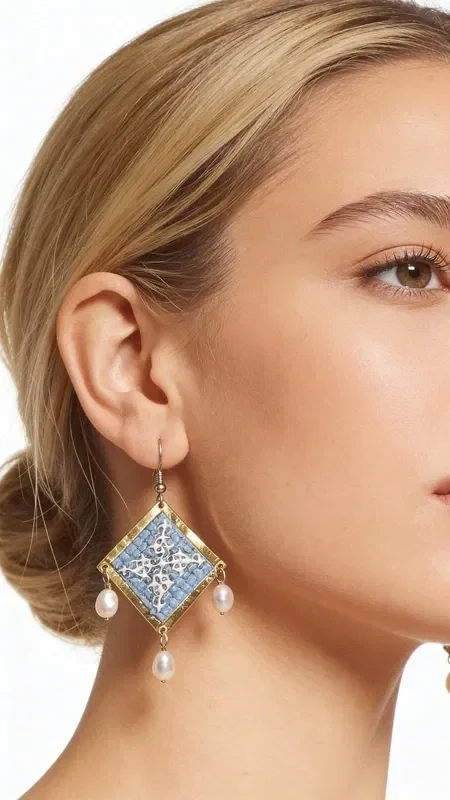 , These statement embroidered earrings in light blue with geometric patterns made of gold thread are the ideal handmade jewelry piece to highlight your uniqueness. These impressive dangle earrings, designed by Greek Jewelry Designer Aikaterini Chalkiadaki, combine the traditional art of embroidery with a modern aesthetic.

The light blue hue combined with the gold thread creates a refined contrast that catches the eye. The geometric patterns add a contemporary touch, while the delicate pearls hanging from the base of the earrings add movement and femininity. Their folklore design makes them ideal for special occasions, from bridal looks to cocktail parties. Perfect earrings for weddings, christenings, and special events. Care for them with attention, avoiding contact with water and perfumes for a longer lifespan.