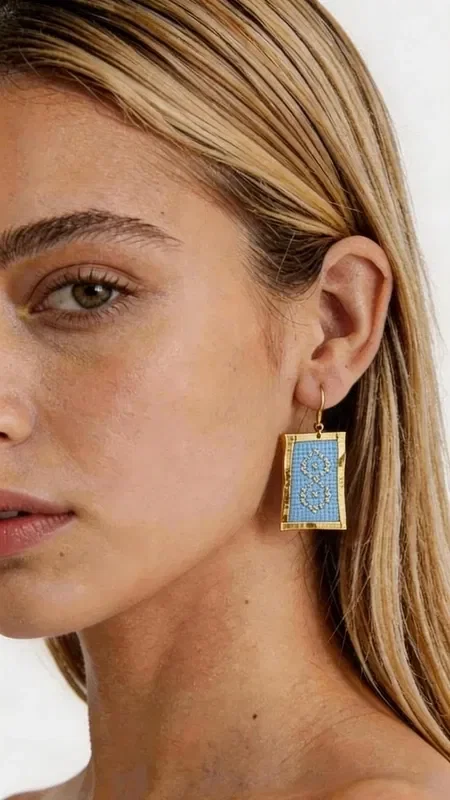 , These statement embroidered earrings in light blue are the perfect choice for women who want to stand out with style and elegance. Designed by Greek Jewelry Designer Aikaterini Chalkiadaki, these striking handmade jewelry pieces combine a modern aesthetic with the traditional technique of embroidery.

The gold thread creates geometric patterns that beautifully frame the light blue color, giving them a unique shine and movement. The rectangular shape of the earrings offers a contemporary look, while the embroidered texture adds depth and character. They are ideal for special occasions and weddings, as well as for adding a sophisticated touch to everyday outfits.

Material: Brass, Fabric

Be sure to store them in a dry place and avoid contact with moisture to preserve their shine. Pair them with simple outfits to highlight their beauty.