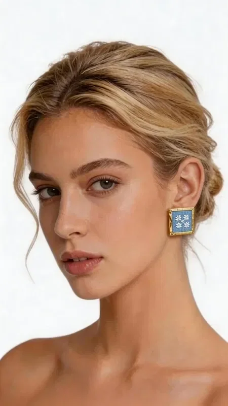 , Embroidered statement earrings that combine the traditional art of embroidery with modern geometric design. These striking light blue earrings, designed by Greek Jewelry Designer Aikaterini Chalkiadaki, feature detailed gold-thread embroidery creating enchanting geometric patterns. The square shape on a vivid light blue background is complemented by gold details that add shine and elegance. The gold thread creates intricate patterns reminiscent of Byzantine art, while the modern cut and contemporary aesthetic make them ideal for modern looks.

These handmade earrings are the perfect choice for those seeking striking jewelry that stands out. Ideal for special occasions, weddings, or stylish everyday looks.

Material: Brass, Fabric

Care: Store in a dry place, away from moisture. Clean gently with a dry cloth.