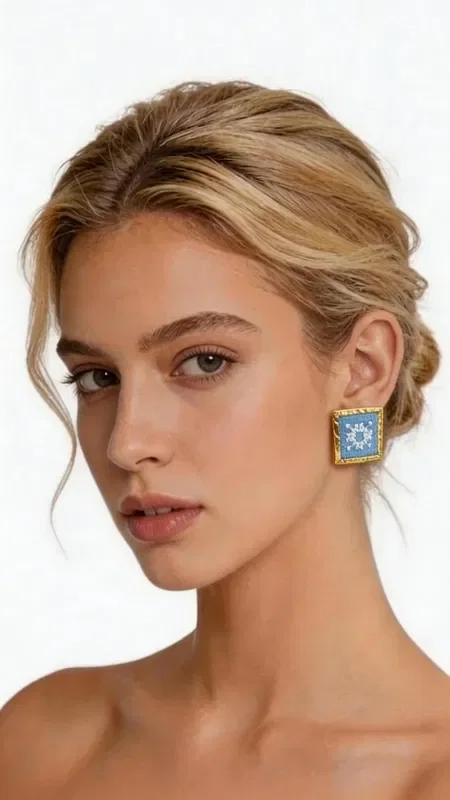 , These statement embroidered earrings with geometric patterns in light blue will add a unique character to every look. These striking handmade earrings, designed by Greek Jewelry Designer Aikaterini Chalkiadaki, combine the traditional art of embroidery with contemporary geometric design.

The gold thread framing the embroidered light blue fabric creates a refined contrast that catches the eye. The square shape with folklore embroidery highlights Greek tradition through a modern aesthetic.

Each earring is handmade with special attention to detail, guaranteeing the high quality and uniqueness of the piece. Ideal for striking appearances, wedding events, or everyday styling that wants to stand out. They pair perfectly with boho outfits, classic dresses, and modern casual looks.

Material: Brass, Fabric

Take care of them with gentle cleaning and store them in a dry place to preserve their shine.