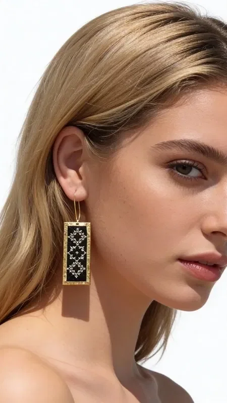 , The embroidered statement earrings with geometric designs, featuring gold thread on a black background, are a stunning piece of jewelry that combines traditional embroidery art with a modern aesthetic. Designed by Greek Jewelry Designer Aikaterini Chalkiadaki, these handmade earrings carry a strong personality and a distinct Greek character.

The rectangular shape with intricate geometric motifs creates a striking visual contrast between the deep black background and the gold thread. Each earring is hand-embroidered with special attention to detail, resulting in a unique piece of jewelry that stands out from the ordinary.

These statement earrings are ideal for special occasions and looks that call for elegance and style. They pair perfectly with black or gold outfits, adding a touch of Greek tradition to any look. Handle them gently and store them in a dry place to preserve their shine.