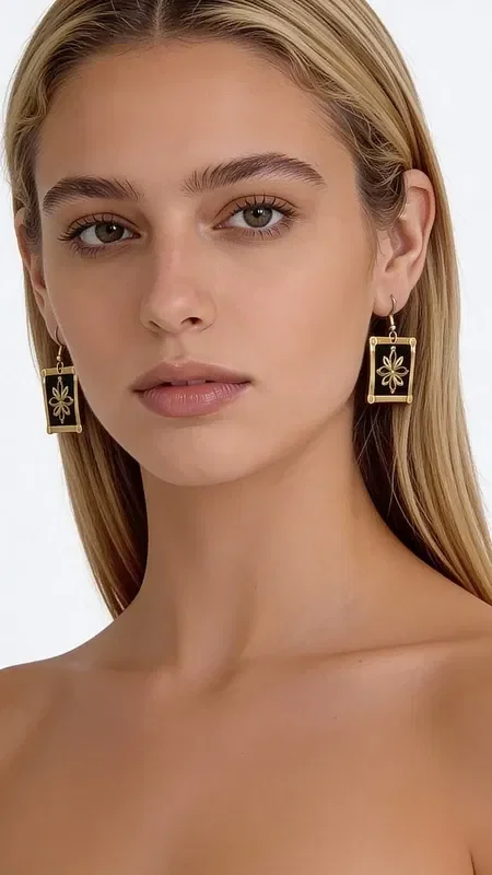 , These embroidered statement earrings with gold thread on a black background are a striking choice that combines the traditional Greek art of embroidery with modern design. Designed by Greek Jewelry Designer Aikaterini Chalkiadaki, these handmade earrings stand out for their exceptional quality and unique aesthetic.

The geometric patterns in gold thread create a striking visual contrast against the black base, offering elegance and style. Their square shape and dangling design make them ideal for special occasions such as weddings or christenings, or for adding a striking touch to your everyday look.

These modern embroidered earrings are perfect for women who love statement jewelry and are looking for something special and original. The art of handmade embroidery gives each piece uniqueness and authenticity. Be sure to store them in a dry place and clean them gently with a soft cloth to preserve their beauty.