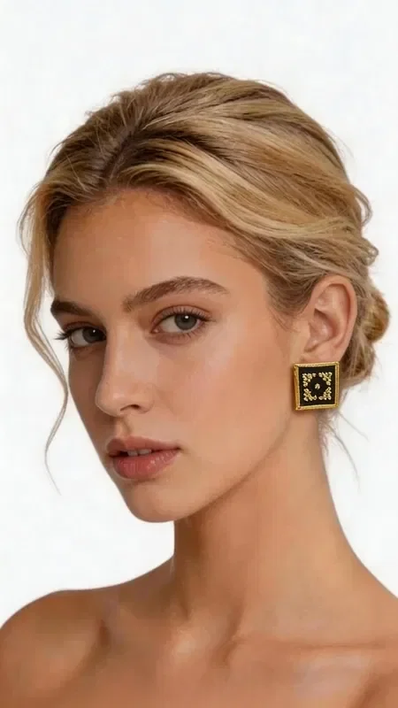 , Stand out with these striking statement embroidered earrings that combine traditional Greek embroidery art with a modern geometric design. Designed by Greek Jewelry Designer Aikaterini Chalkiadaki, these unique handmade earrings feature a rich gold-thread embroidered pattern on an elegant black background.

Each earring is a small work of art, with intricate geometric motifs that create a stunning visual effect. The gold thread shines beautifully against the black base, offering an impressive combination that suits both everyday and formal looks.

These modern dangle earrings are ideal for women who love original jewelry with a Greek character. Their square shape offers a contemporary aesthetic, while the embroidered detail brings tradition to the forefront.

Material: Brass, Fabric

Take care of your earrings by storing them in a dry place and avoiding contact with moisture and chemical products.