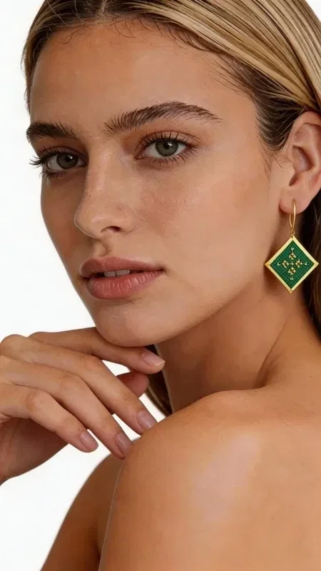 , These striking embroidered statement earrings with a geometric design will become the ultimate accessory for every look. Their square shape in a green shade with golden details creates a unique aesthetic that combines modern style with the traditional art of embroidery.

Designed by Greek Jewelry Designer Aikaterini Chalkiadaki, these handmade earrings stand out for the exceptional quality of the gold thread and the contemporary interpretation of geometric motifs. The green color adds freshness and vibrancy, while the golden details highlight the elegance of the design.

These dangle earrings are ideal for evening outings, special occasions, or whenever you want to add a touch of style to your everyday look. Their unique shape and color scheme make them completely versatile, pairing perfectly with monochrome outfits and adding an impressive character.

Material: Brass, Fabric

Care for your earrings by storing them in a dry place and gently cleaning them with a soft cloth.