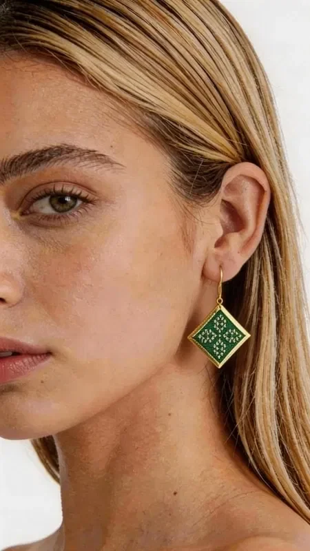 , Striking embroidered statement earrings that combine the traditional art of embroidery with contemporary geometric design. Designed by Greek Jewelry Designer Aikaterini Chalkiadaki, these unique handmade earrings in green will become the focal point of any outfit. The refined diamond shape with its detailed gold-thread embroidered motifs creates an elegant contrast with the vivid green color. Each earring is handmade with special attention to detail, combining folklore design elements with a modern aesthetic. Ideal for weddings, special occasions, or whenever you want to add a touch of color and elegance to your everyday look. Their lightweight design makes them comfortable for all-day wear. Store the earrings in a dry place, avoiding contact with water and chemical products to preserve their shine and beauty.