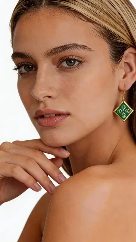 , Striking embroidered statement earrings that combine the traditional art of embroidery with contemporary geometric design. Designed by Greek Jewelry Designer Aikaterini Chalkiadaki, these unique handmade earrings in green will become the focal point of any outfit. The refined diamond shape with its detailed gold-thread embroidered motifs creates an elegant contrast with the vivid green color. Each earring is handmade with special attention to detail, combining folklore design elements with a modern aesthetic. Ideal for weddings, special occasions, or whenever you want to add a touch of color and elegance to your everyday look. Their lightweight design makes them comfortable for all-day wear. Store the earrings in a dry place, avoiding contact with water and chemical products to preserve their shine and beauty.
