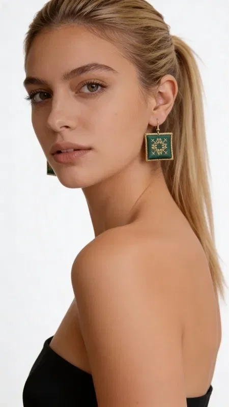, Striking statement earrings embroidered with gold thread that combine the unique aesthetic of Greek folklore with modern elegance. These handmade jewelry pieces, designed by Greek Jewelry Designer Aikaterini Chalkiadaki, feature an enchanting square shape in vivid green with gold embroidery forming geometric patterns.

The embroidered earrings feature detailed craftsmanship with gold thread creating refined designs on a green base. The embroidered fabric is surrounded by a gold frame that gives it a luxurious look, while their size makes them ideal for statement looks. They are perfect for wedding events, special occasions, or whenever you want to add an impressive touch to your everyday style.

Take care of your embroidered earrings by avoiding contact with water and storing them in a dry place to preserve their beauty.
