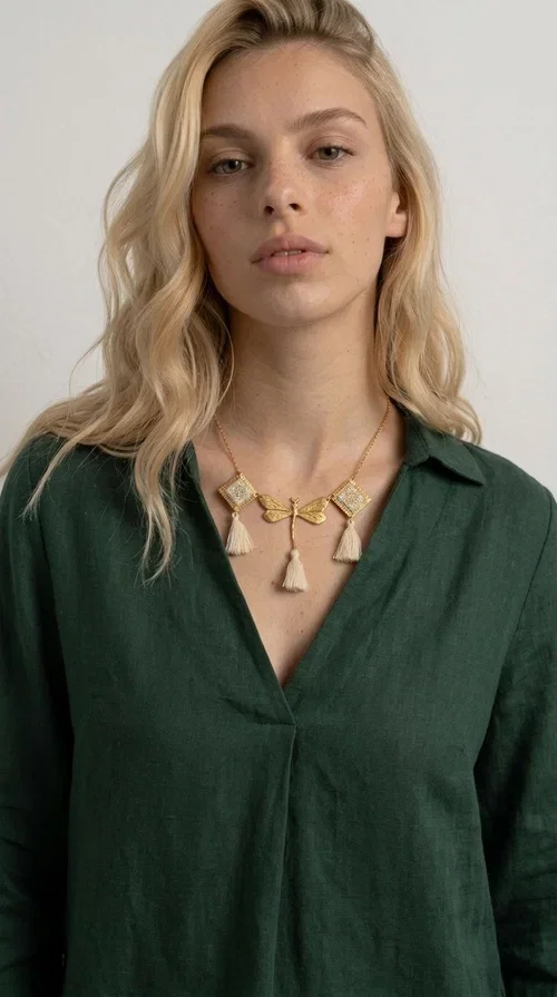 , An embroidered necklace that blends folk aesthetics with modern elegance — the Statement necklace KOL-4771 is the ideal choice for those seeking jewelry with character and warmth.

Designed by Greek Jewelry Designer Aikaterini Chalkiadaki, this necklace is a handmade work of art inspired by Greek folklore aesthetics. Made of brass and fabric, it features geometric embroidered motifs in gold tones alternating with a central butterfly motif, while four ivory fabric tassels add movement and boho-chic flair. The ivory and gold palette creates a timelessly elegant combination, suitable for every season.

Wear it with a white linen shirt or a simple dress to fully showcase its beauty. Ideal for summer looks, weddings, christenings, or even for everyday outings that call for something special.