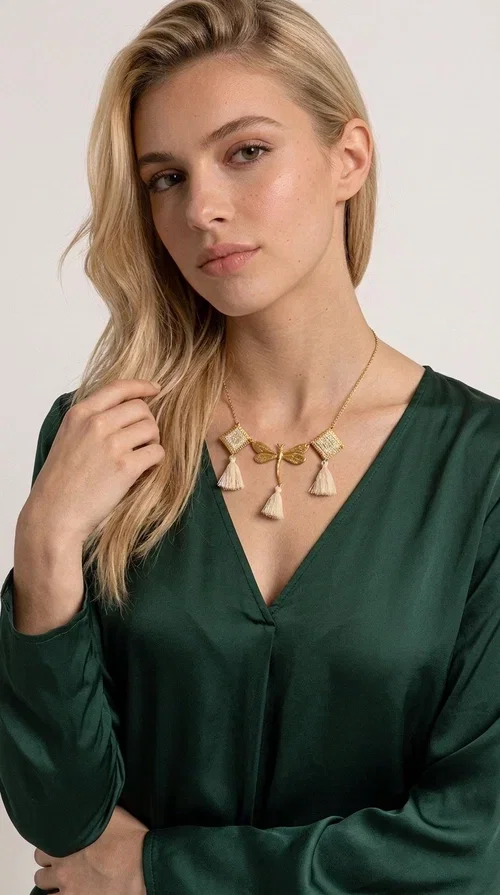 , An embroidered necklace that blends folk aesthetics with modern elegance — the Statement necklace KOL-4771 is the ideal choice for those seeking jewelry with character and warmth.

Designed by Greek Jewelry Designer Aikaterini Chalkiadaki, this necklace is a handmade work of art inspired by Greek folklore aesthetics. Made of brass and fabric, it features geometric embroidered motifs in gold tones alternating with a central butterfly motif, while four ivory fabric tassels add movement and boho-chic flair. The ivory and gold palette creates a timelessly elegant combination, suitable for every season.

Wear it with a white linen shirt or a simple dress to fully showcase its beauty. Ideal for summer looks, weddings, christenings, or even for everyday outings that call for something special.