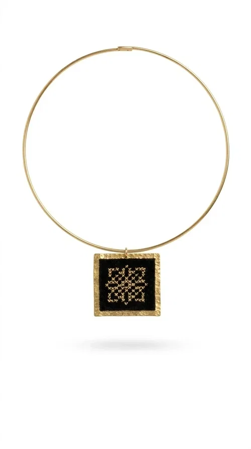 , An embroidered necklace that instantly catches every eye — this Statement Necklace with geometric patterns on a black background blends the traditional art of embroidery with a modern, minimal aesthetic.

Designed by Greek Jewelry Designer Aikaterini Chalkiadaki, this handmade necklace is a unique piece that showcases Greek craftsmanship in all its glory. The square pendant, made of brass and fabric, features an intricately worked geometric motif inspired by traditional folk art — creating an effect that resembles embroidery in a black-and-gold color palette. The choker hugs the neck with elegance, while the raised gold frame of the pendant adds a distinctive depth and character to the overall look.

Ideal for casual style with a blazer or for evening looks, this striking necklace pairs equally well with a white shirt or a black dress. If you're looking for large, eye-catching necklaces with soul and story, this is the answer.