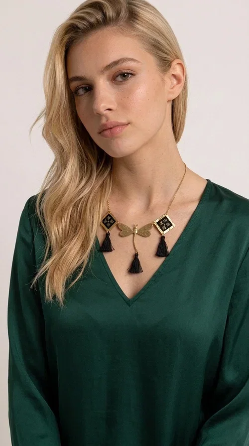 , A statement embroidered necklace that instantly catches the eye — the perfect piece for every woman who wants to express herself with style and personality. Designed by Greek Jewelry Designer Aikaterini Chalkiadaki, this unique necklace combines the traditional art of embroidery with a modern, striking result. Its geometric composition and bold black palette make it a timeless statement piece that truly stands out.

The necklace features three square brass motifs with black embroidered geometric patterns, inspired by folk aesthetics. At the center sits a striking gold-tone metal element shaped like a dragonfly or butterfly, while elegant black fabric tassels hang from each motif, adding movement and lightness. The chain is gold-toned brass, durable and lightweight to wear.

Ideal for daytime looks with white or monochrome outfits, as well as for evening occasions that call for character. It pairs perfectly with simple dresses, tailored outfits, and casual looks.