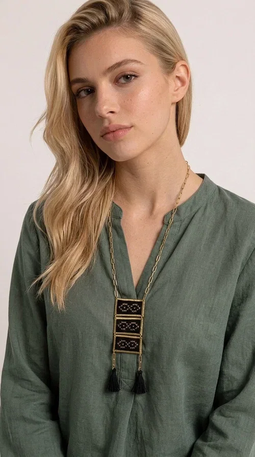 , An embroidered necklace that blends tradition with contemporary style — the Statement Necklace KOL-4754 is the perfect choice for any woman who wants to express herself through her jewelry. Designed by Greek Jewelry Designer Aikaterini Chalkiadaki, this handmade necklace features geometric embroidered patterns inspired by Greek folk tradition, creating a unique piece full of character.

Three rectangular brass frames in a gold hue are adorned with black embroidery in geometric motifs, while black tassels at the bottom add movement and dramatic flair. The gold paperclip-style chain completes the look with an elegant, modern touch. The result is a striking long necklace that suits both everyday and evening outfits equally well.

Wear it over a simple shirt or dress to create a look full of personality. It's the perfect gift choice, and also the perfect way to turn heads at an evening event.