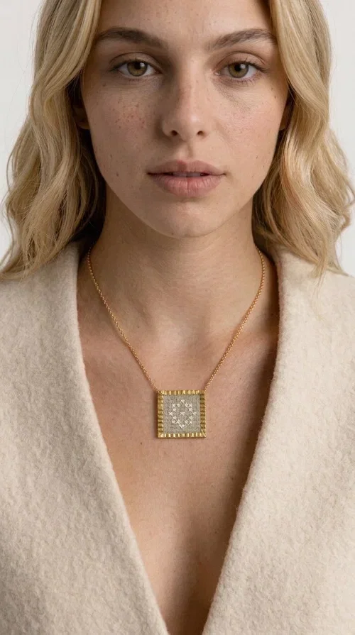 , A statement embroidered necklace that combines tradition with contemporary style — ideal for those who love striking jewelry with character. Designed by Greek Jewelry Designer Aikaterini Chalkiadaki, this handmade necklace features geometric embroidered patterns in cream tones, inspired by folk art and Greek tradition. The square pendant with a brass frame and fabric surface makes for a unique piece of jewelry that stands out from the ordinary.

The delicate gold-tone chain highlights the pendant, making it stand out in both casual and more formal looks. The geometric embroidered motifs give a sense of vintage elegance, while the cream tones make it versatile — pairing well with dresses, jackets, and even casual outfits. An ideal gift for women who appreciate handmade jewelry with a Greek soul.