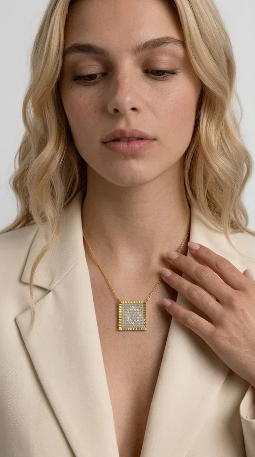 , A statement embroidered necklace that combines tradition with contemporary style — ideal for those who love striking jewelry with character. Designed by Greek Jewelry Designer Aikaterini Chalkiadaki, this handmade necklace features geometric embroidered patterns in cream tones, inspired by folk art and Greek tradition. The square pendant with a brass frame and fabric surface makes for a unique piece of jewelry that stands out from the ordinary.

The delicate gold-tone chain highlights the pendant, making it stand out in both casual and more formal looks. The geometric embroidered motifs give a sense of vintage elegance, while the cream tones make it versatile — pairing well with dresses, jackets, and even casual outfits. An ideal gift for women who appreciate handmade jewelry with a Greek soul.