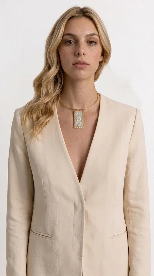 , A statement embroidered necklace that instantly catches the eye — featuring geometric patterns in cream tones and an aesthetic that blends folk tradition with contemporary style. Designed by Greek Jewelry Designer Aikaterini Chalkiadaki, this handmade piece is a distinctive choice for those seeking something beyond the ordinary.

The rectangular embroidered pendant in cream-gold tones is crafted from brass and fabric, featuring dense embroidery in geometric motifs reminiscent of folklore aesthetics. It hangs from a delicate gold-toned choker-torque style chain that elegantly and strikingly highlights the neckline. The extensive decoration with small shimmering elements adds richness and depth to the overall composition.

Ideal for casual chic or smart casual looks, it pairs beautifully with a white T-shirt, a blazer, or a summer dress. It also makes an excellent gift idea for women who appreciate handmade jewelry with a distinctive character.