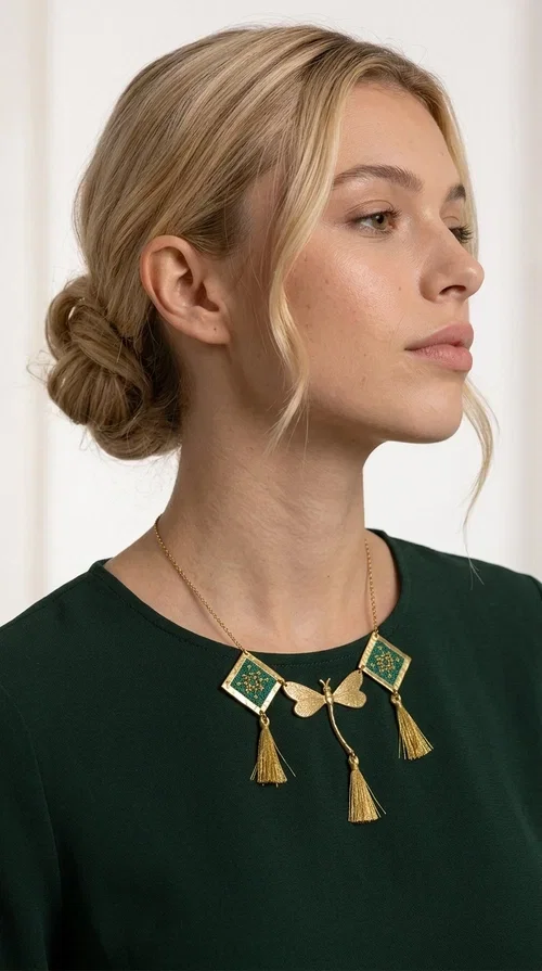 , A statement embroidered necklace that doesn't go unnoticed — featuring geometric patterns inspired by Greek tradition and a contemporary aesthetic that suits every strong feminine presence.

Designed by Greek Jewelry Designer Aikaterini Chalkiadaki, this handmade necklace combines brass and fabric in a composition strongly reminiscent of traditional folk embroidery art. Two diamond shapes of green embroidered fabric with gold geometric motifs frame a gold dragonfly at the center, while three gold tassels add movement and grace to the overall design. The result is a piece of jewelry with a deeply folklore aesthetic and, at the same time, a distinctly modern character.

Ideal for women who love striking jewelry that tells a story. It pairs perfectly with simple, monochrome looks — such as a white or cream shirt — highlighting its color and patterns. Suitable for both daytime and evening looks, receptions, weddings, or trips where you want to stand out.