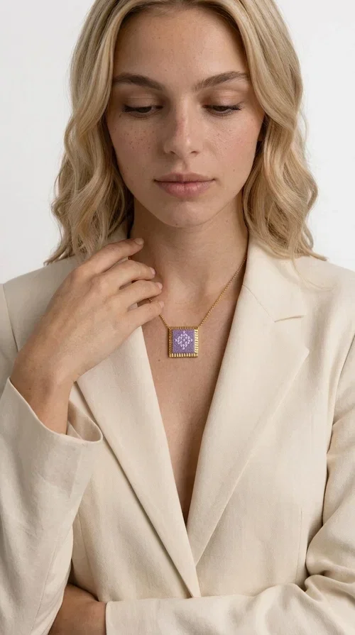 , The embroidered lilac necklace with geometric patterns is a statement piece that combines the traditional art of embroidery with a modern aesthetic, creating a result that instantly stands out. Designed by Greek Jewelry Designer Aikaterini Chalkiadaki, this handmade necklace is the perfect blend of folklore inspiration and contemporary style.

The rectangular pendant in lilac shades features detailed geometric motifs embroidered on fabric, framed by gold-tone brass that adds elegance and structure. The gold box chain harmoniously completes the look, while the larger size of the pendant makes it ideal for those who want to make a statement with their style.

Wear it with casual or formal outfits — it pairs equally well with a linen dress for a summer stroll and a blazer for a professional look. An ideal gift for every woman who loves unique, handmade jewelry with a Greek soul.