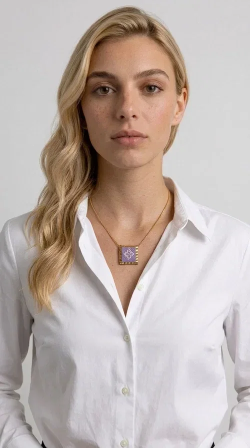, The embroidered lilac necklace with geometric patterns is a statement piece that combines the traditional art of embroidery with a modern aesthetic, creating a result that instantly stands out. Designed by Greek Jewelry Designer Aikaterini Chalkiadaki, this handmade necklace is the perfect blend of folklore inspiration and contemporary style.

The rectangular pendant in lilac shades features detailed geometric motifs embroidered on fabric, framed by gold-tone brass that adds elegance and structure. The gold box chain harmoniously completes the look, while the larger size of the pendant makes it ideal for those who want to make a statement with their style.

Wear it with casual or formal outfits — it pairs equally well with a linen dress for a summer stroll and a blazer for a professional look. An ideal gift for every woman who loves unique, handmade jewelry with a Greek soul.