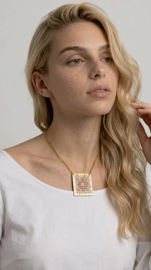 , An embroidered necklace that combines the traditional art of embroidery with a modern aesthetic — ideal for every woman who loves statement jewelry with character. Designed by Greek Jewelry Designer Aikaterini Chalkiadaki, this handmade necklace is a unique example of folklore-inspired aesthetics drawing from Greek tradition.

The square pendant in pink and gold tones is adorned with geometric patterns embroidered on fabric, set into a gold-tone brass base with a textured surface. The gold rolo chain gives the piece an elegant, contemporary touch that makes it easy to style — whether with an everyday casual look or an evening outfit.

The pink palette with gold embroidered details offers a warm, feminine feel, while the handmade construction guarantees uniqueness. An ideal gift for women who appreciate jewelry with history and soul.