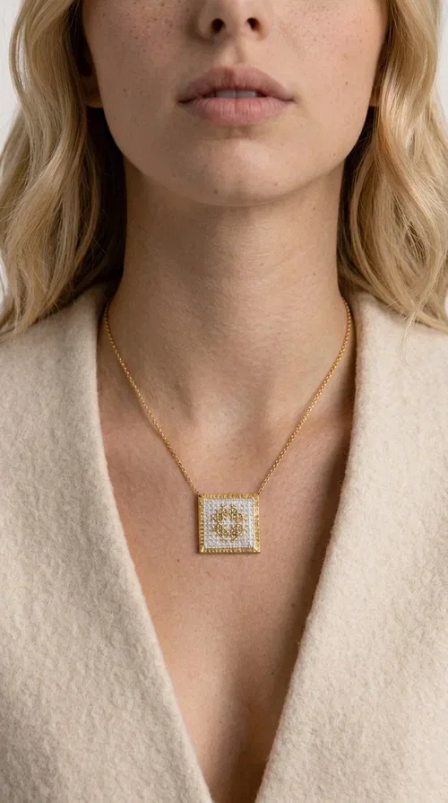 , The embroidered necklace with geometric patterns is a statement piece of jewelry that combines the traditional art of embroidery with a modern, minimal aesthetic. Designed by Greek Jewelry Designer Aikaterini Chalkiadaki, this necklace is a handmade piece with strong character — ideal for women who appreciate authenticity and want to stand out.

The square pendant is adorned with white embroidery in geometric motifs inspired by folk tradition, while the gold-toned brass frame adds warmth and elevates the level of elegance. The gold-tone chain blends softly into the overall look, creating a piece of jewelry that suits casual looks just as well as formal occasions.

Wear it over a white t-shirt or under a blazer for an effortless chic look. It also makes a wonderful gift for women who love handmade jewelry with a Greek identity.